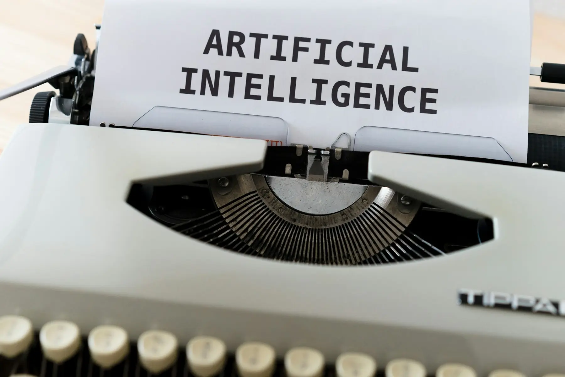 Schreibmaschine mit dem Wort Artificial Intelligence auf dem Papier
